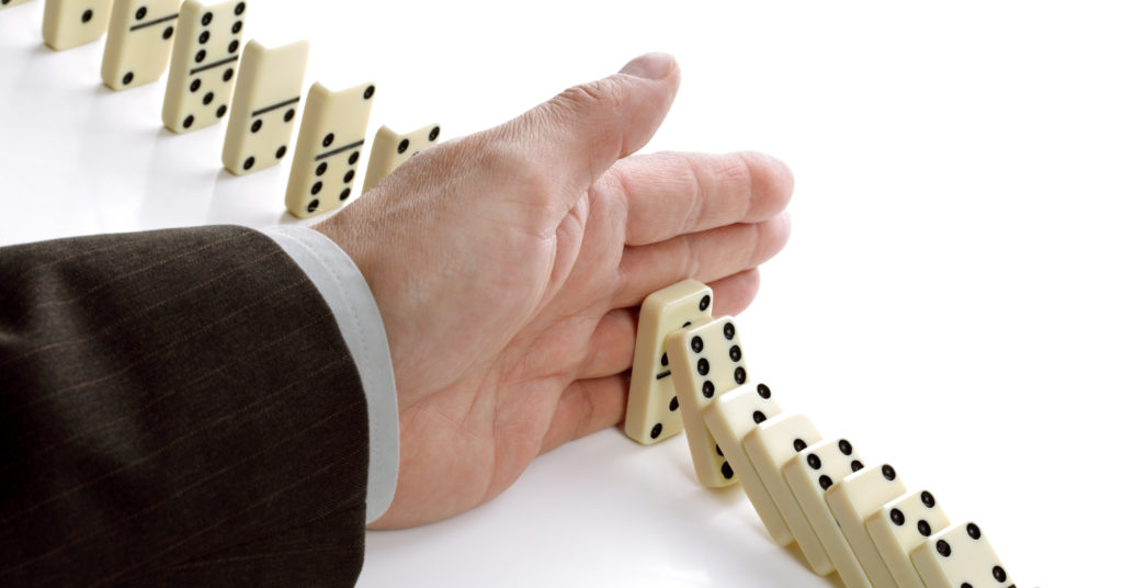 Hand stopping dominoes from falling- erp change management